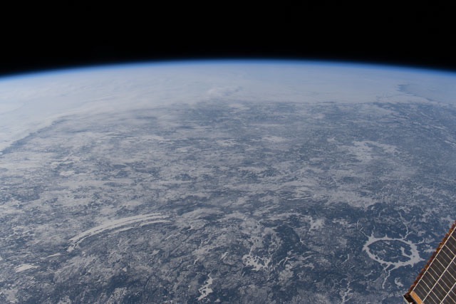 Earth seen from space with a luminous blue atmospheric line